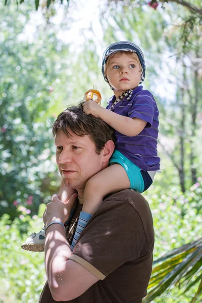 Happy Young father giving little boy a ride on shoulders — Stock Photo, Image