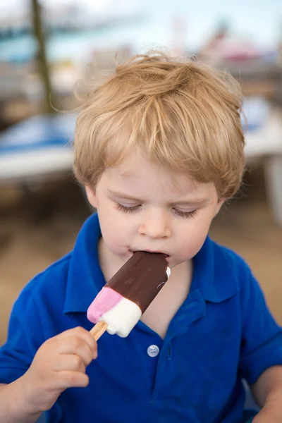 Pequena criança loira comendo sorvete de chocolate — Fotografia de Stock