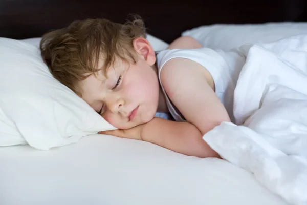 Lille søte småbarnsgutt som sover i senga si – stockfoto