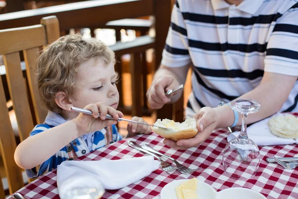 Joven padre e hijo desayunando juntos en verano — Foto de Stock