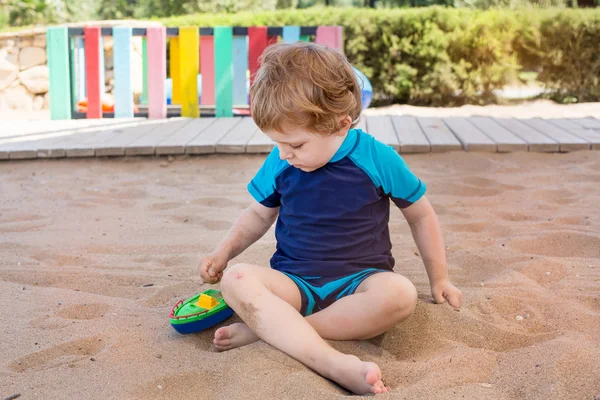 Kleine peuter jongen spelen met zand en speelgoed — Stockfoto