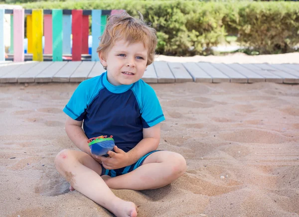 Kleiner Junge spielt mit Sand und Spielzeug — Stockfoto