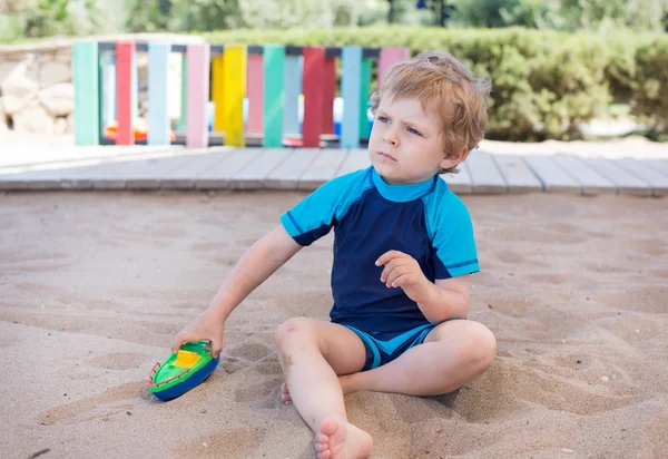 Kum ve oyuncak oynarken küçük yürümeye başlayan çocuk — Stok fotoğraf