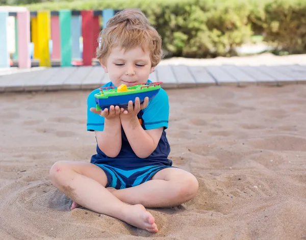 Piccolo bambino ragazzo che gioca con sabbia e giocattolo — Foto Stock