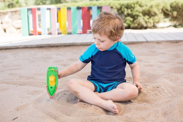 Piccolo bambino ragazzo che gioca con sabbia e giocattolo — Foto Stock