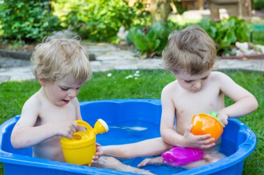 İki kardeş çocukları yaz aylarında su ile eğleniyor