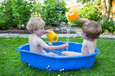 İki kardeş çocukları yaz aylarında su ile eğleniyor