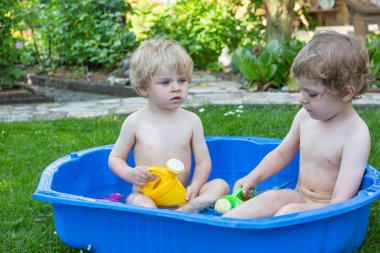 İki kardeş çocukları yaz aylarında su ile eğleniyor