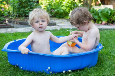 İki kardeş çocukları yaz aylarında su ile eğleniyor