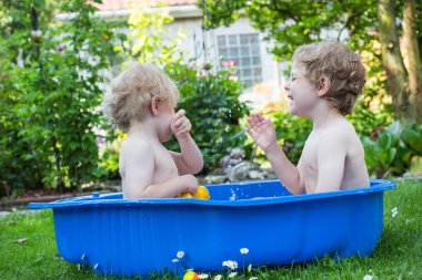 İki kardeş çocukları yaz aylarında su ile eğleniyor
