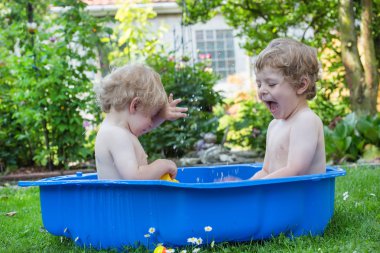 İki kardeş çocukları yaz aylarında su ile eğleniyor