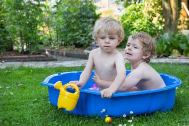 İki kardeş çocukları yaz aylarında su ile eğleniyor