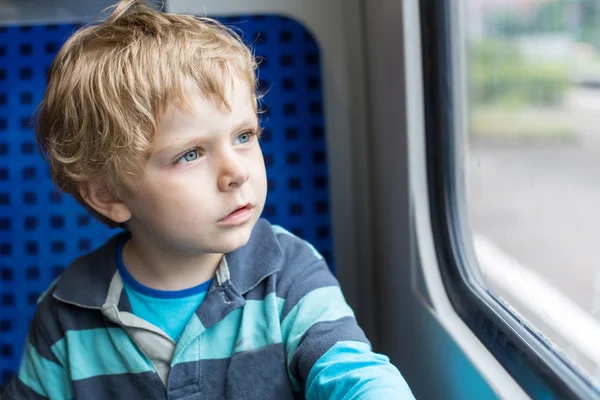 Schattige kleine jongen kijkt uit raam van de trein — Stockfoto