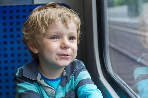 Netter kleiner Junge schaut aus dem Zugfenster — Stockfoto