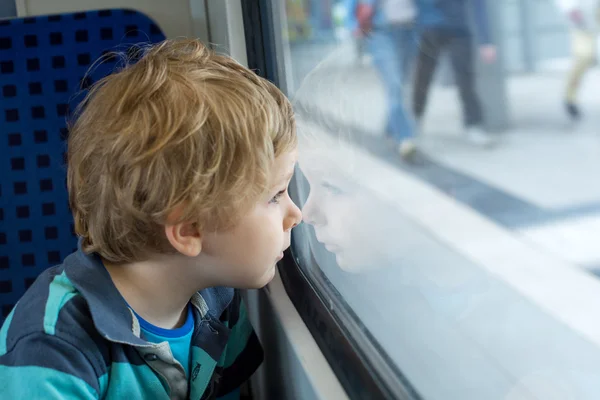 Milý chlapeček při pohledu z okna vlaku — Stock fotografie