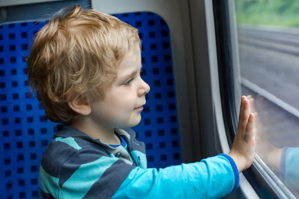 Sevimli küçük çocuk tren pencereden dışarı bakarak — Stok fotoğraf
