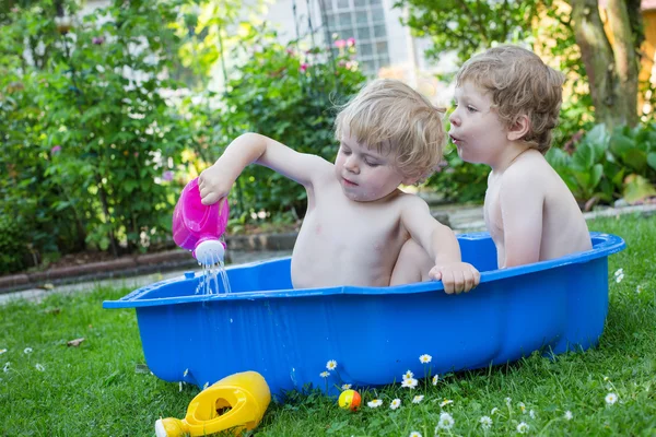 Twee broer of zus jongens plezier maken met water in de zomer — Stockfoto