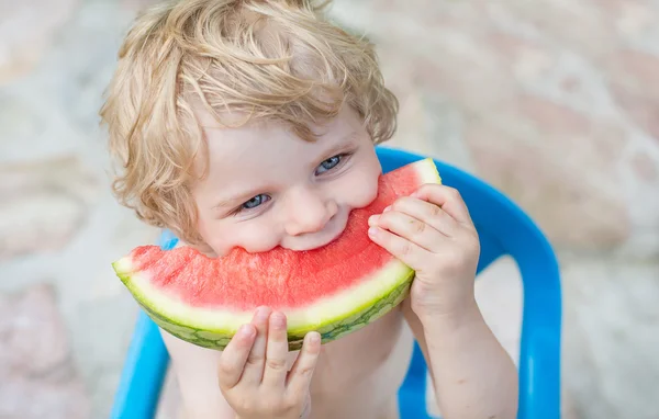 スイカを食べるブロンドの毛で愛らしい小さな幼児男の子 — ストック写真