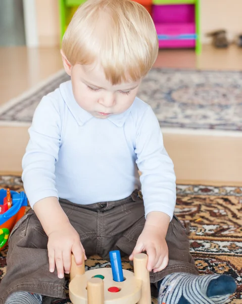 Pequeño niño jugando con juguetes de madera — Foto de Stock