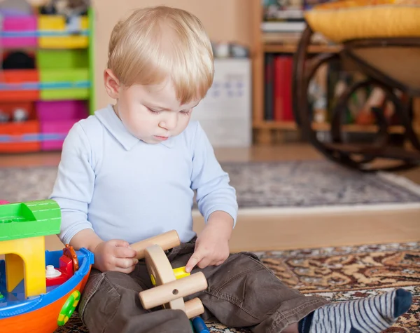 Menino criança brincando com brinquedos de madeira — Fotografia de Stock