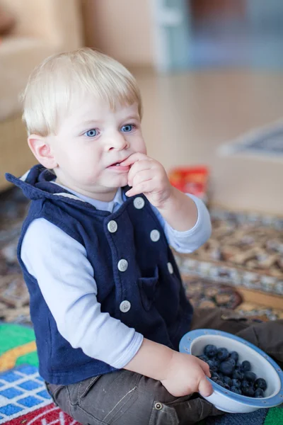 Kleine peuter jongen eten blueberry binnen — Stockfoto