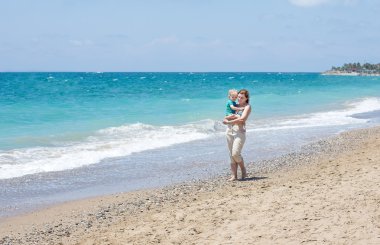 mutlu anne ve küçük bebek oğlu having fun beach tatil