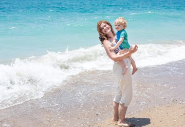 mutlu anne ve küçük bebek oğlu having fun beach tatil
