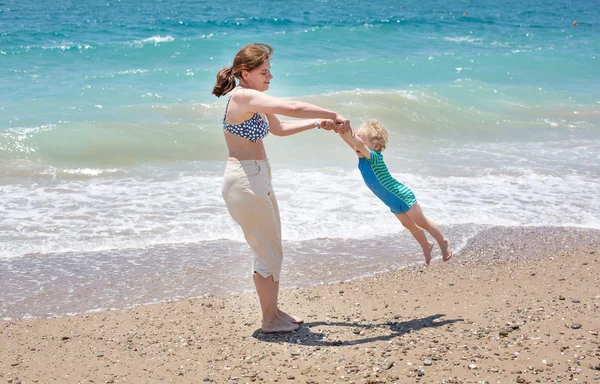 Bonne mère et petit fils bébé s'amusent à la plage vacances — Photo