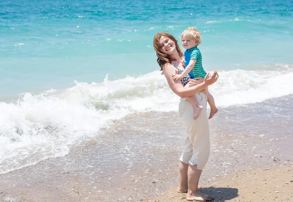 Bonne mère et petit fils bébé s'amusent à la plage vacances — Photo