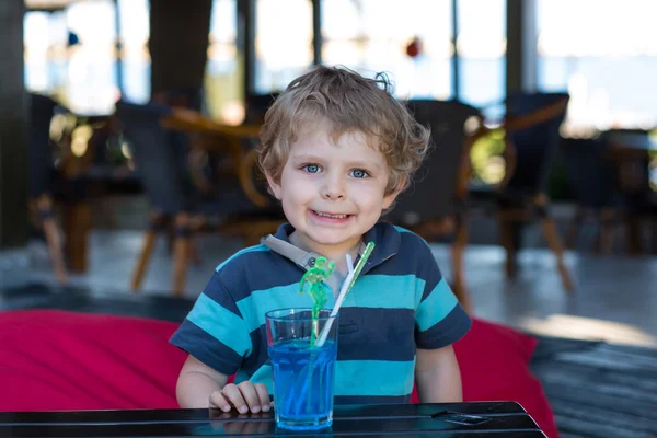 Malý Plavovlasý chlapec seděl na vysoké židle v kavárně s koktejlem — Stock fotografie