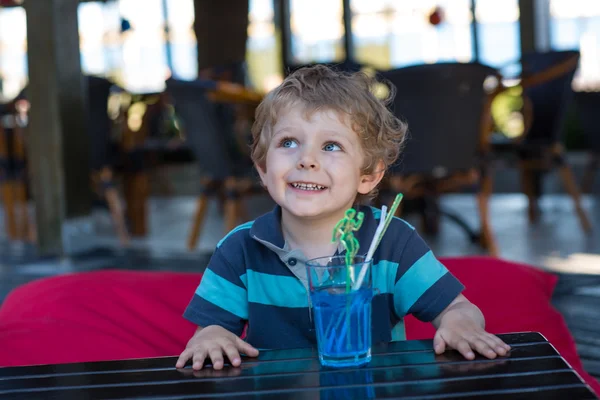 Malý Plavovlasý chlapec seděl na vysoké židle v kavárně s koktejlem — Stock fotografie