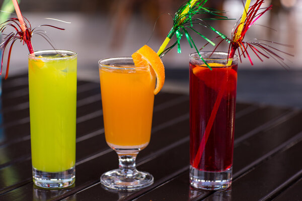 Colorful cocktails with straw on wood table