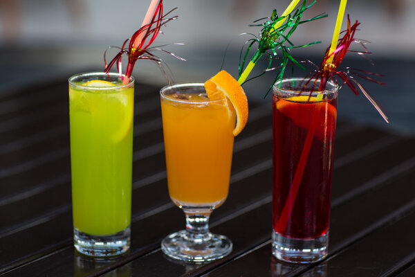Colorful cocktails with straw on wood table