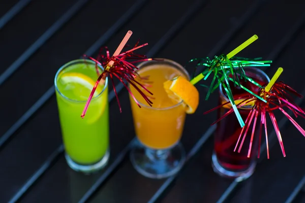 Красочные коктейли с соломой на деревянном столе — стоковое фото