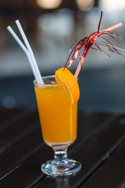 Свежий апельсиновый сок с соломой на столе — стоковое фото
