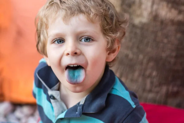 Petit garçon blond assis sur une chaise haute dans un café avec un cocktail — Photo