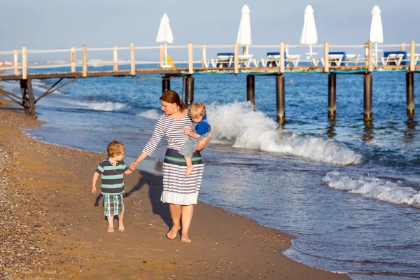 Szczęśliwa matka i dwoje dzieci trochę spaceru na plaży — Zdjęcie stockowe