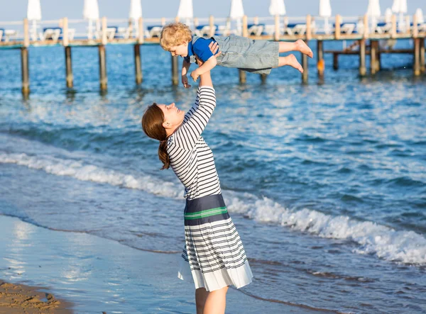 Szczęśliwą matką i małego synka, zabawy na plaży wakacje — Zdjęcie stockowe