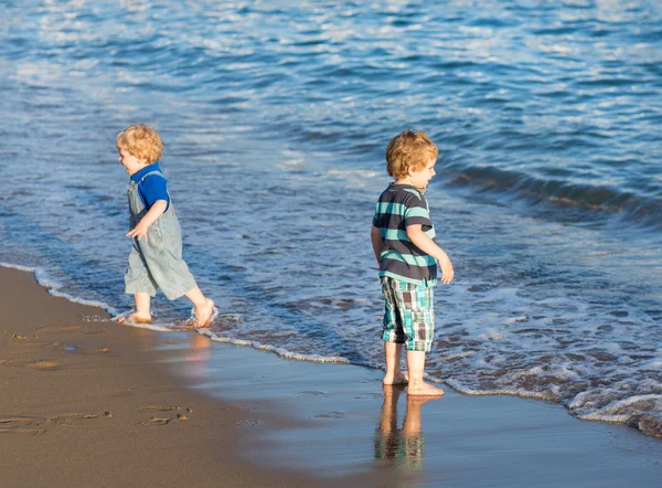 Maluch mały chłopiec bawi się piasek i kamienie na plaży — Zdjęcie stockowe