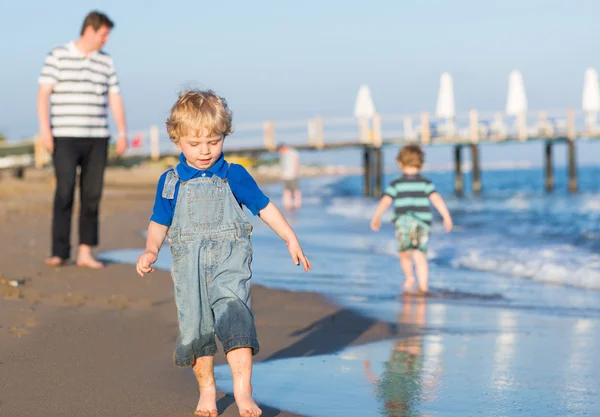 Buon padre e due piccoli figli si divertono in vacanza al mare — Foto Stock