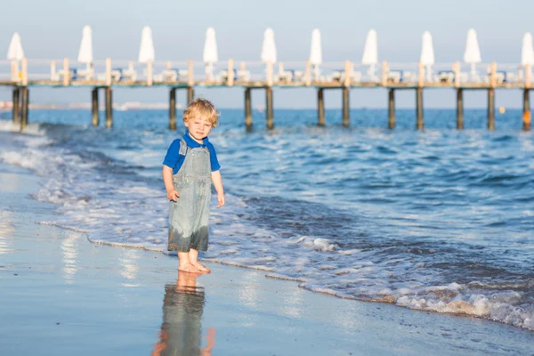 Menino pequeno se divertindo na praia no verão — Fotografia de Stock