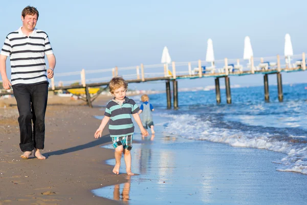 Mutlu baba ve iki küçük oğlu having fun beach tatil — Stok fotoğraf