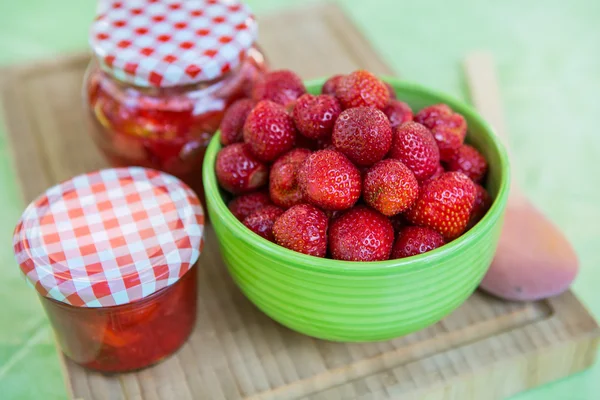 Hemmagjord jordgubbssylt i olika burkar och färska mogna strawbe — Stockfoto