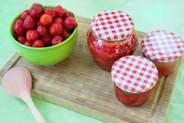 Zelfgemaakte aardbeienjam in verschillende potten en verse rijpe strawbe — Stockfoto