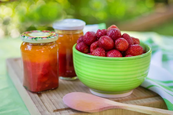 Marmellata di fragole fatta in casa in diversi barattoli e fragola fresca matura — Foto Stock