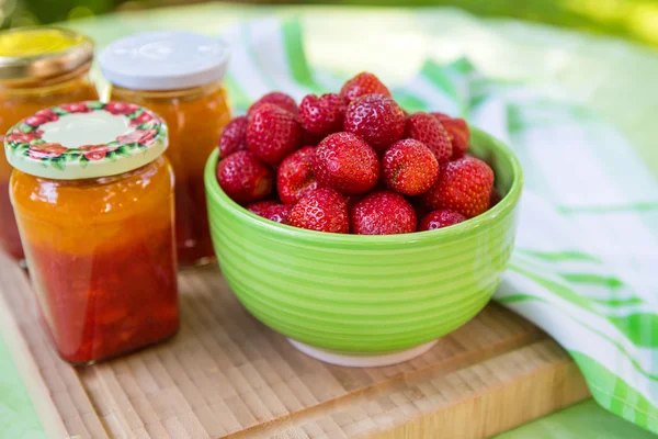 Zelfgemaakte aardbeienjam in verschillende potten en verse rijpe strawbe — Stockfoto