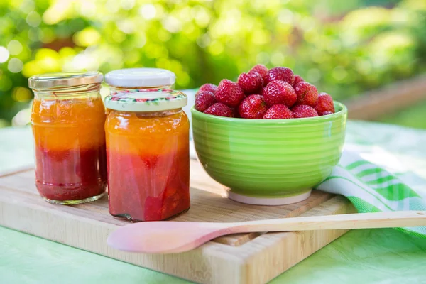 Homemade strawberry jam in different jars and fresh ripe strawbe — Stock Photo, Image
