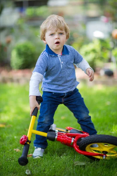 2 anos de idade criança montando em sua primeira bicicleta — Fotografia de Stock