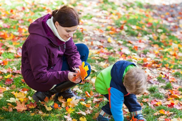 Piccolo bambino e giovane madre nel parco autunnale — Foto Stock