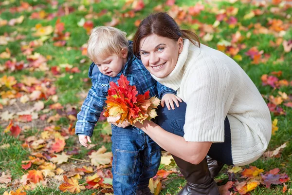 Kleines Kleinkind und junge Mutter im Herbstpark — Stockfoto